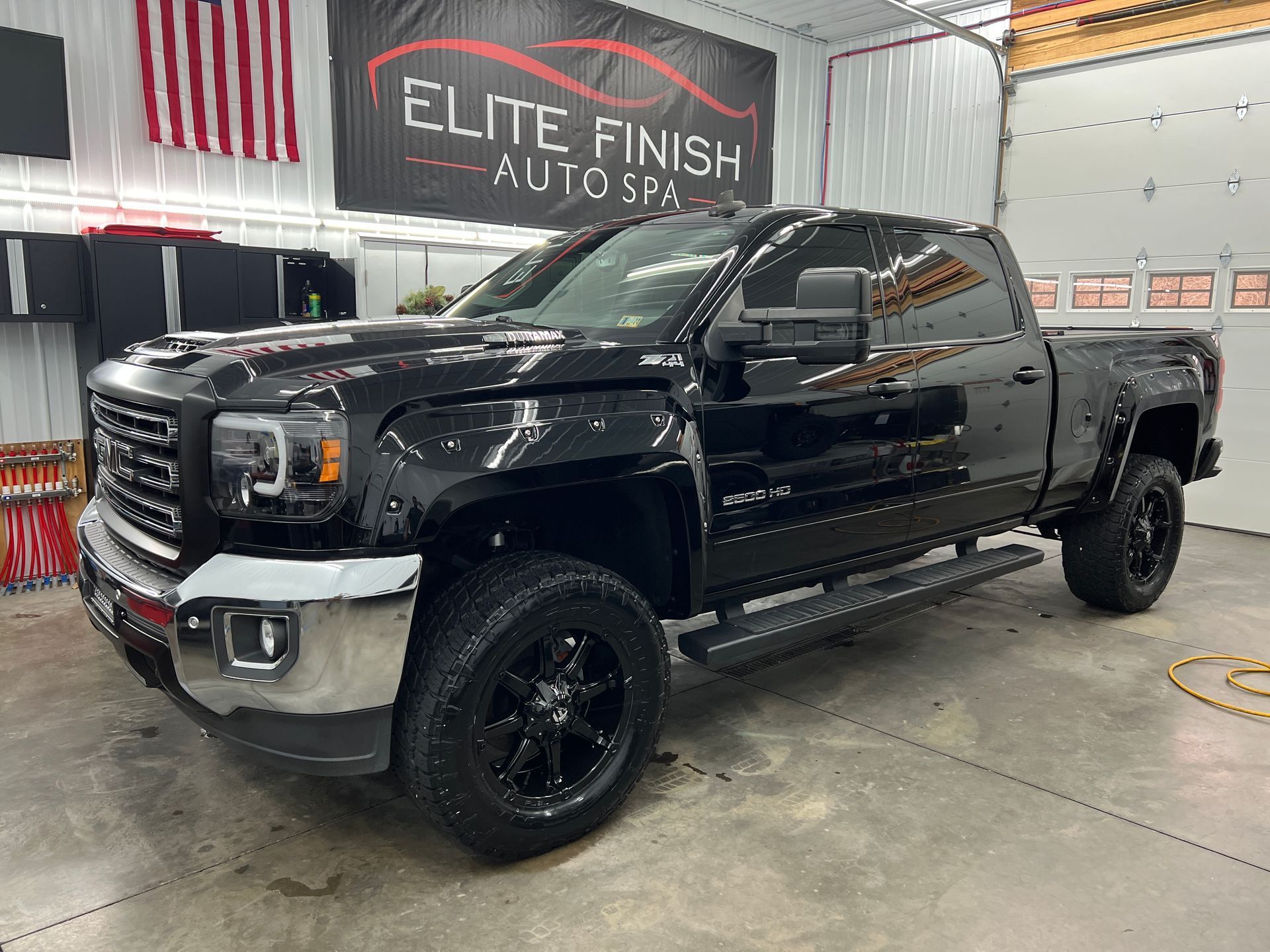A black pickup truck is parked in a garage.