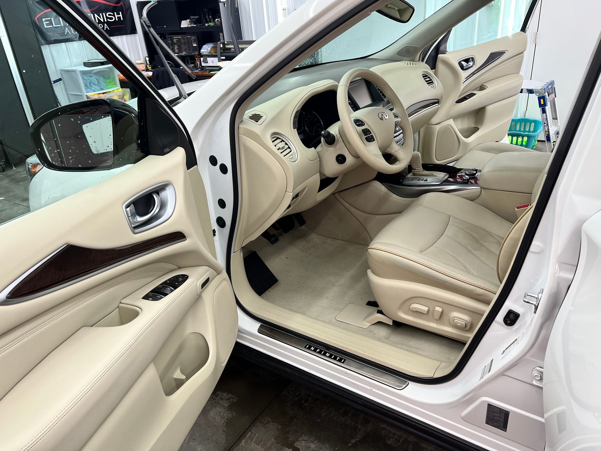 The interior of a white car with the door open.