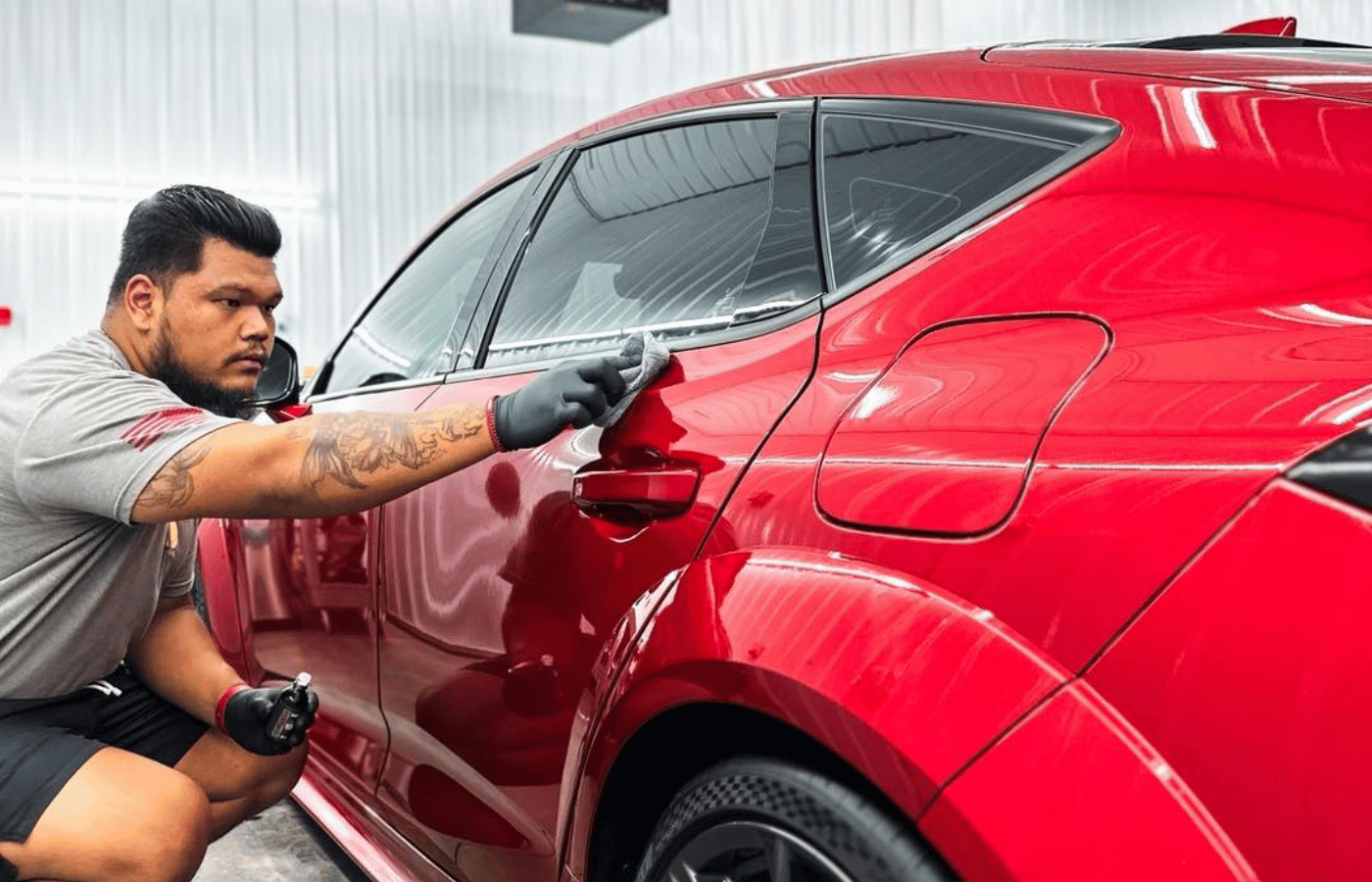 A man is wrapping a car with plastic wrap.