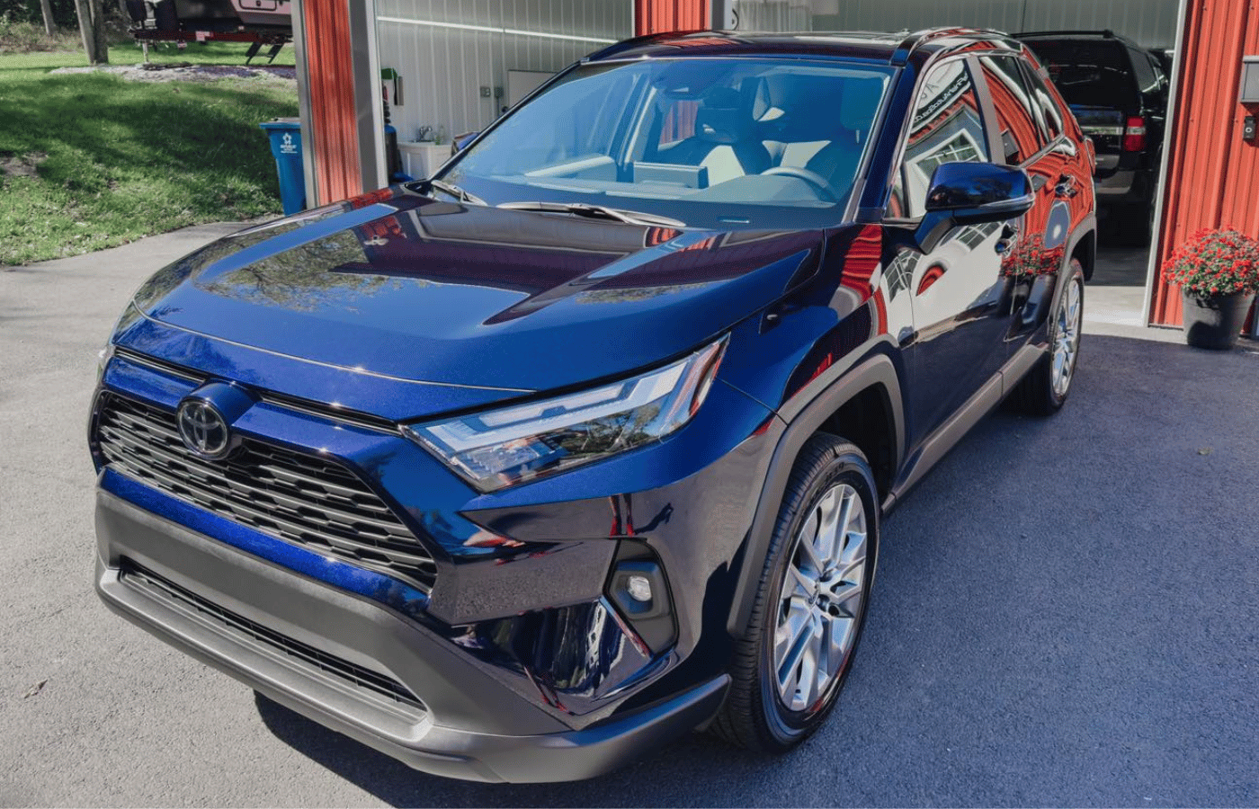 A man is cleaning the back of a white sports car.