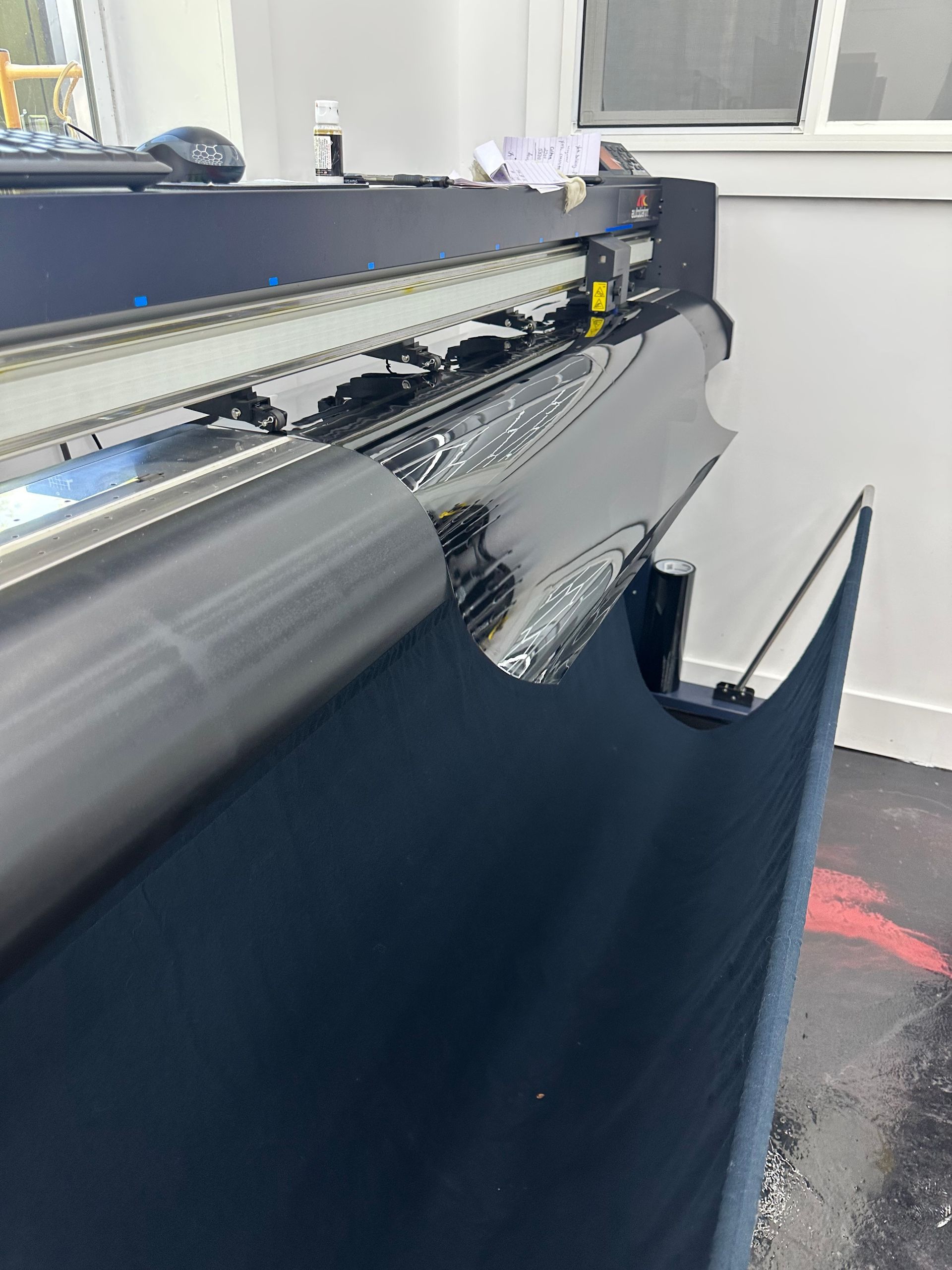 A machine is cutting a piece of fabric in a room.