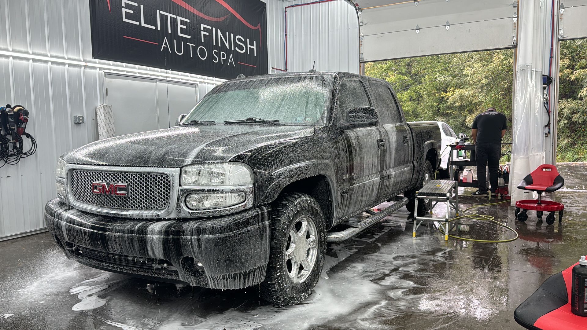 A person is washing a car with foam.