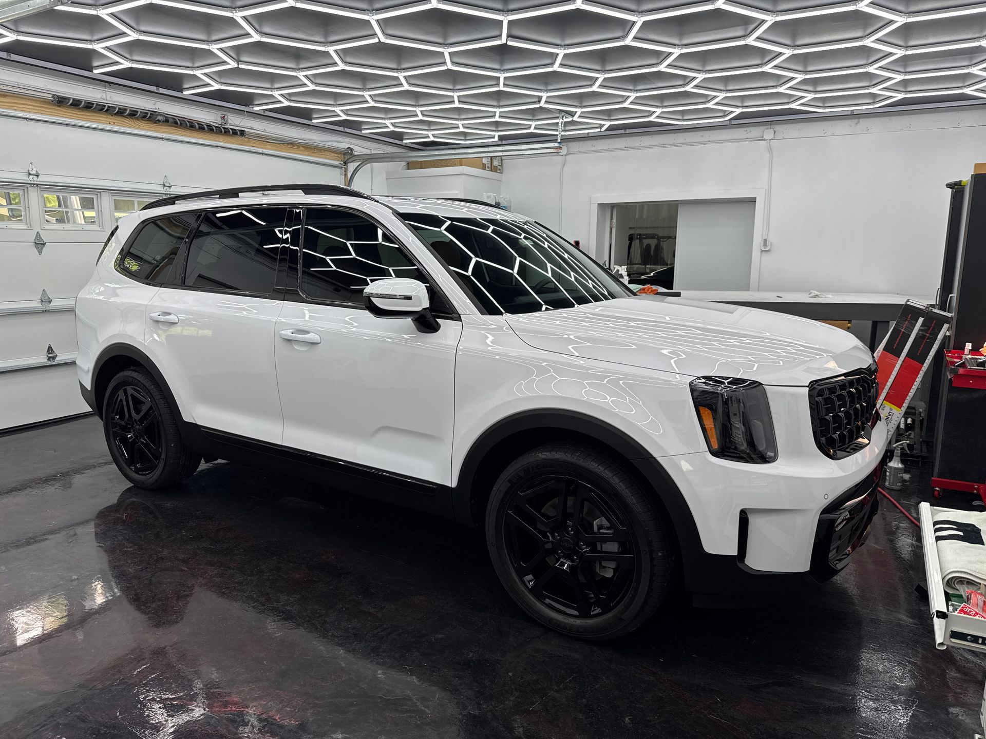 A white suv is parked in a garage.