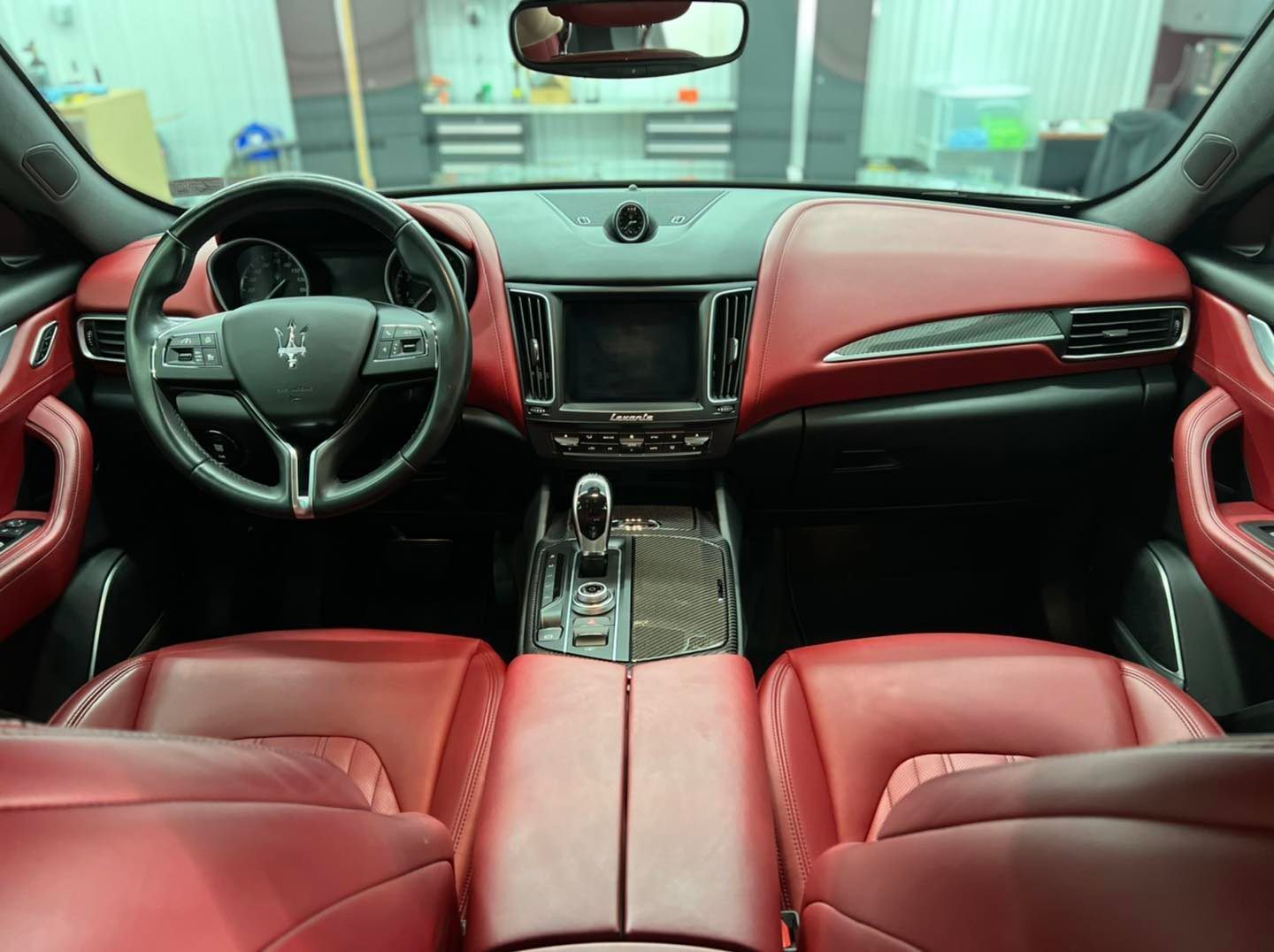 The interior of a car with red seats and a steering wheel.