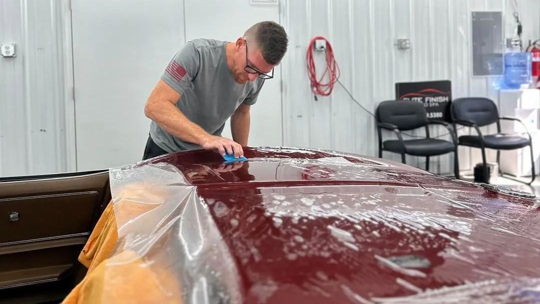 A porsche 911 is covered in foam at a car wash.