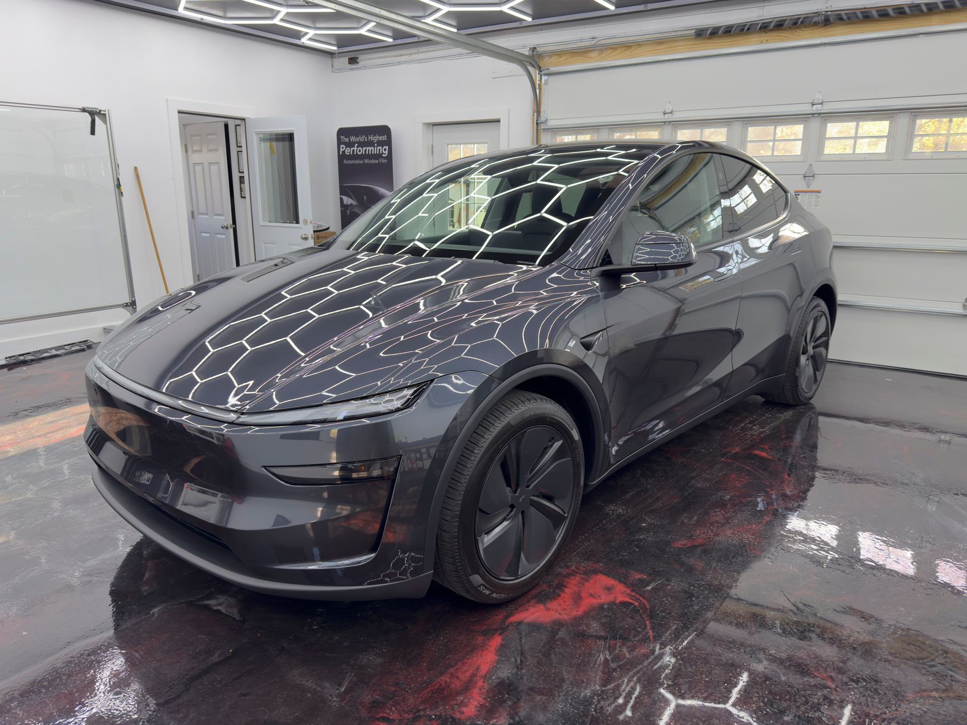 A tesla model y is parked in a garage.