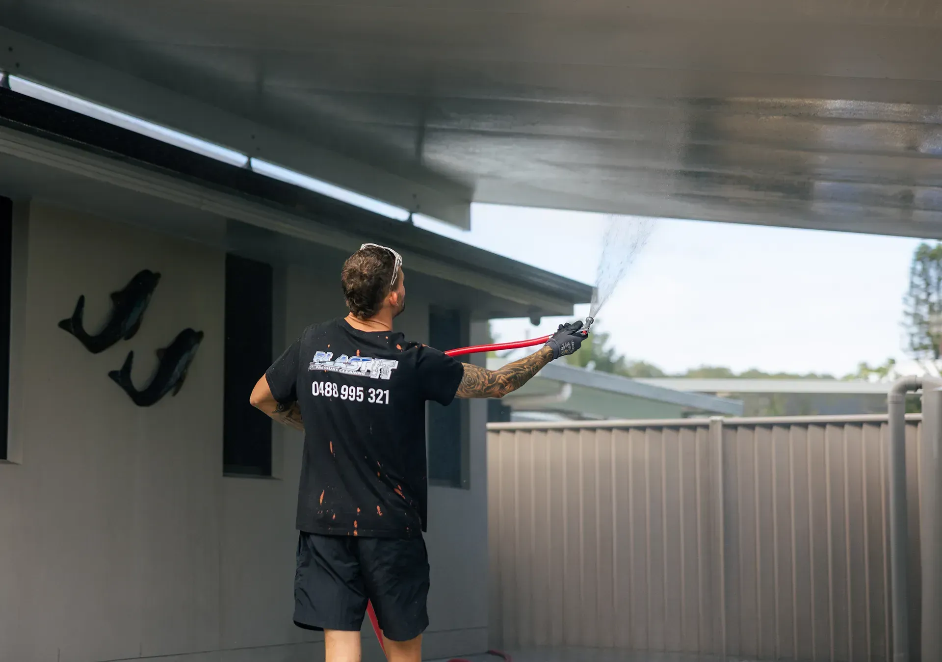 Man pressure washing a patio ceiling outside a house. — Blast It Pressure Cleaning - Gold Coast In Gold Coast, QLD