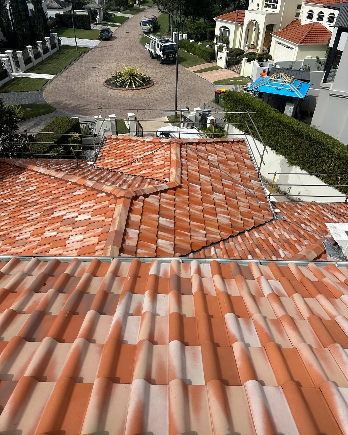 Red clay tile roof with a view of a street and houses below.
