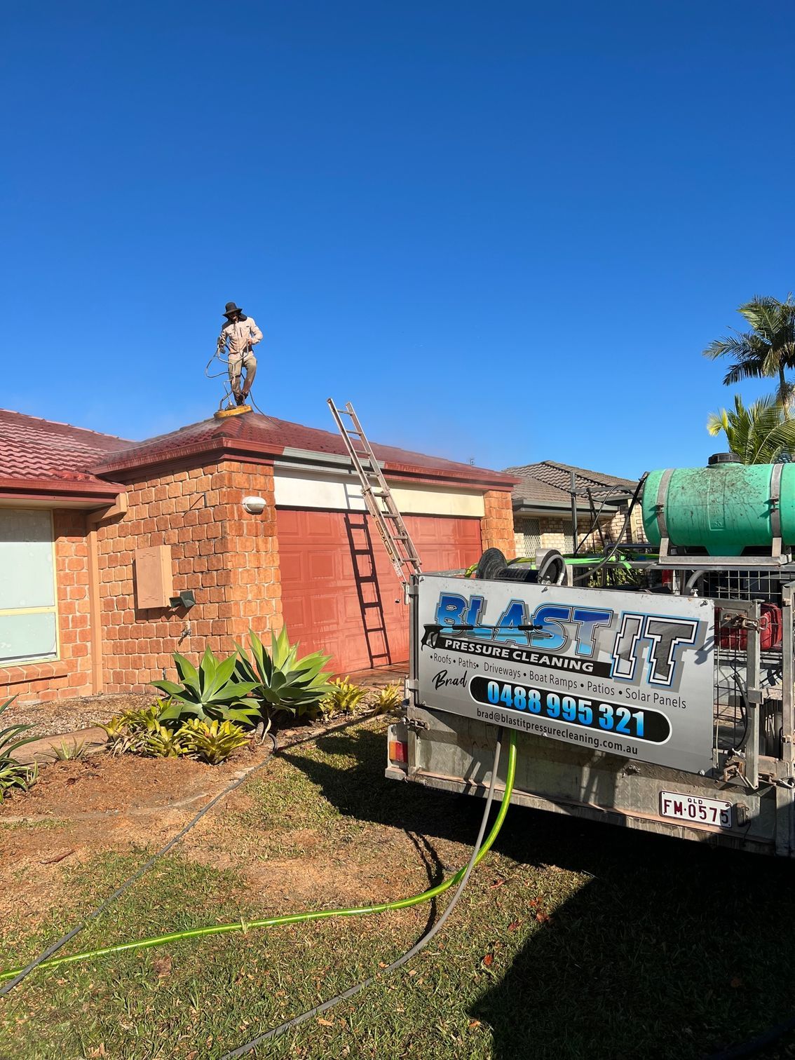 Man on Roof, Ladder, Trailer With Company Logo, Hose, Brick House — Blast It Pressure Cleaning - Gold Coast In Gold Coast, QLD