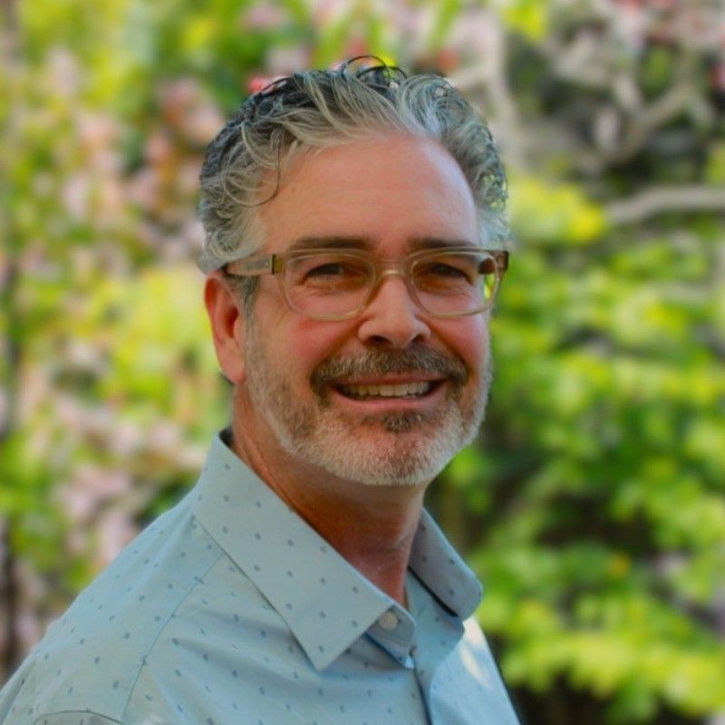 A man with glasses is smiling in a picture