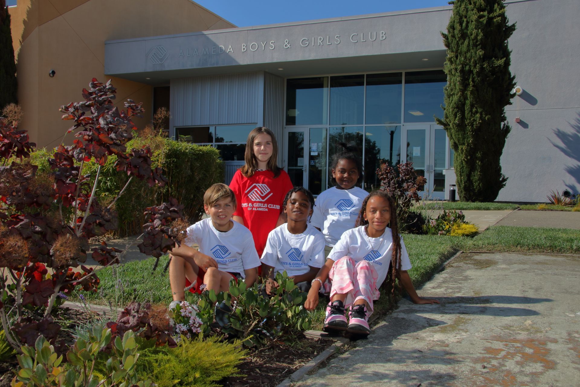 A group of children posing for a picture in front of a building