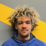 A man with curly hair is smiling for the camera.