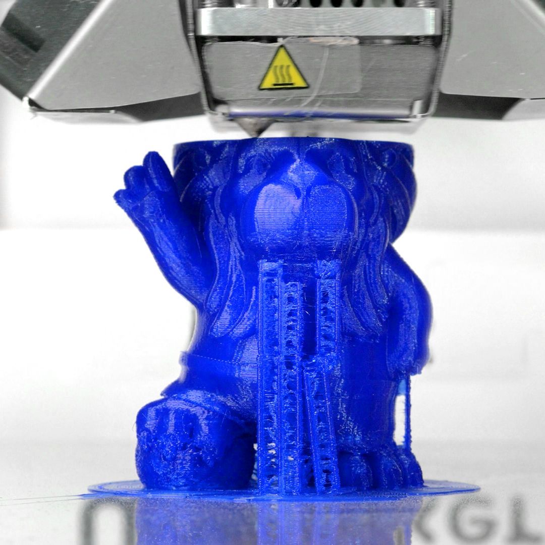 A 3d printer is printing a blue teddy bear