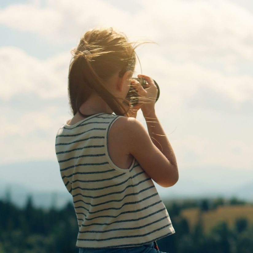A young girl is taking a picture with a camera