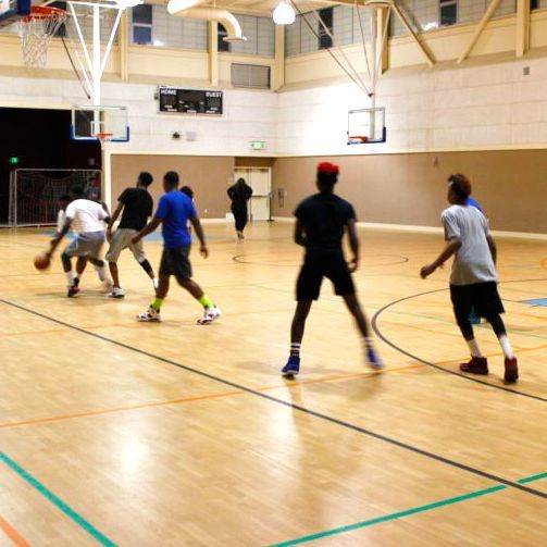 A group of people are playing basketball in a gym