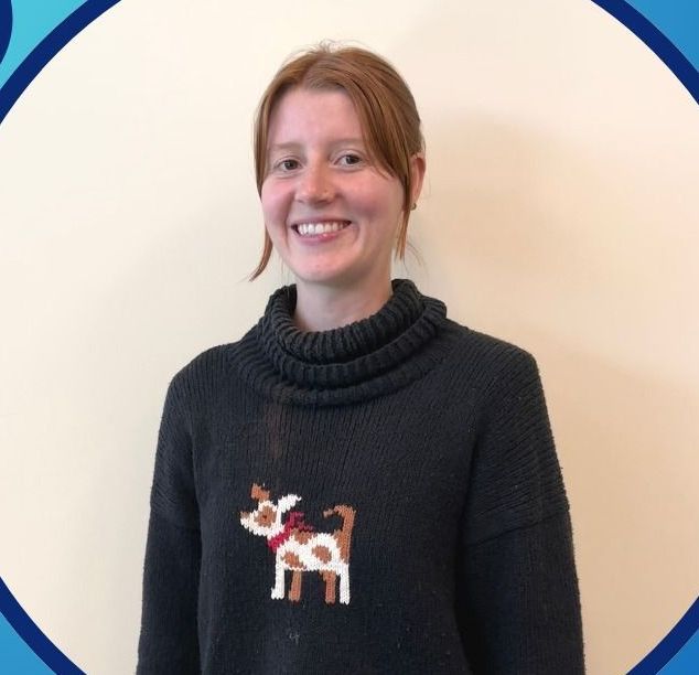 A woman in a white sweater is smiling for the camera.