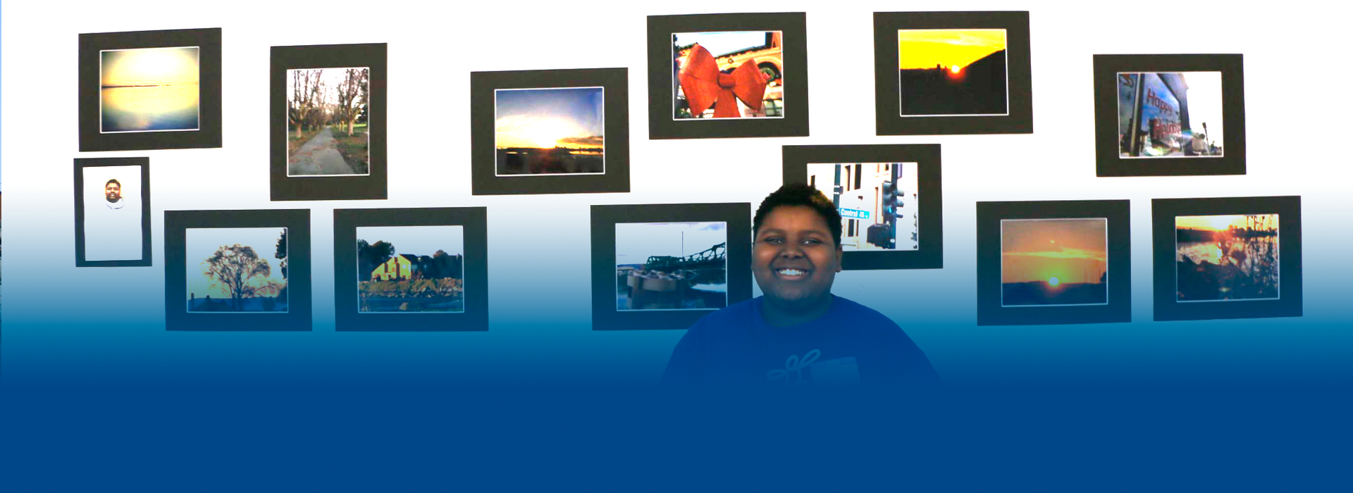 A woman is standing in front of a wall of pictures