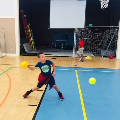 A young boy playing basketball in a gym