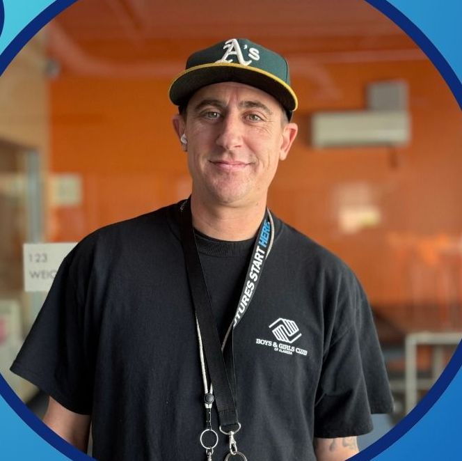 A man wearing a hat and a black shirt is smiling for the camera.