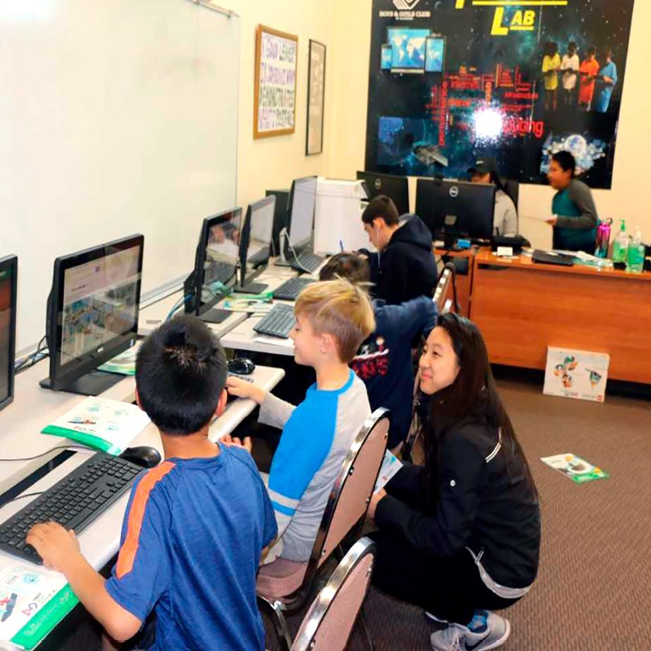 A group of children are working on computers in a lab