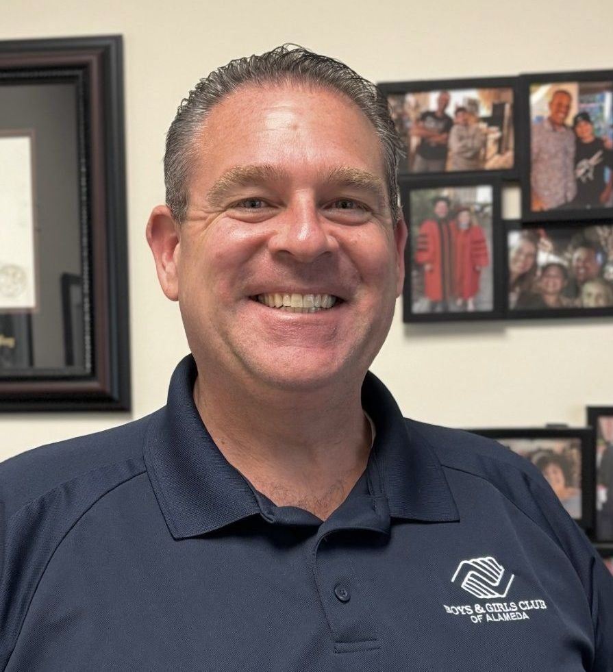 A man in a black shirt is smiling for the camera.