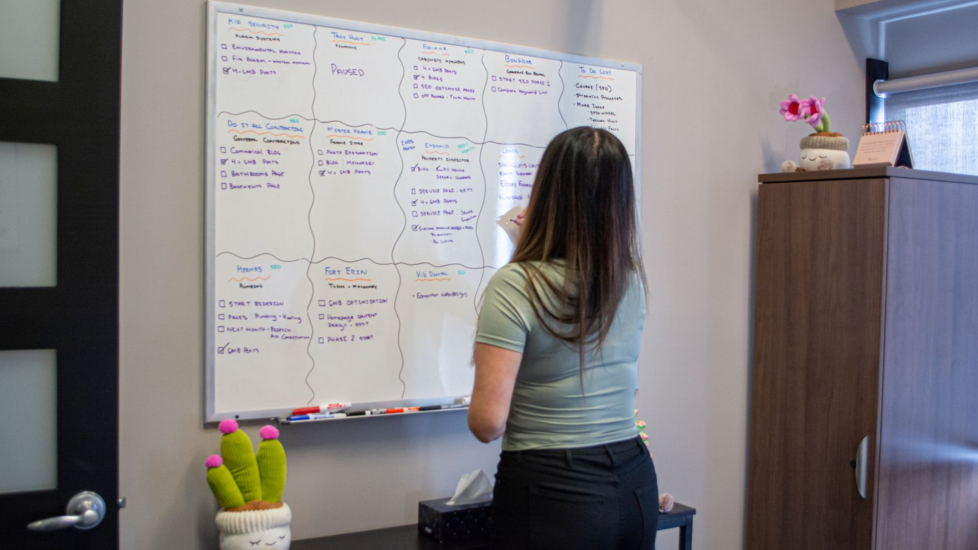 Woman writing on a whiteboard in an office