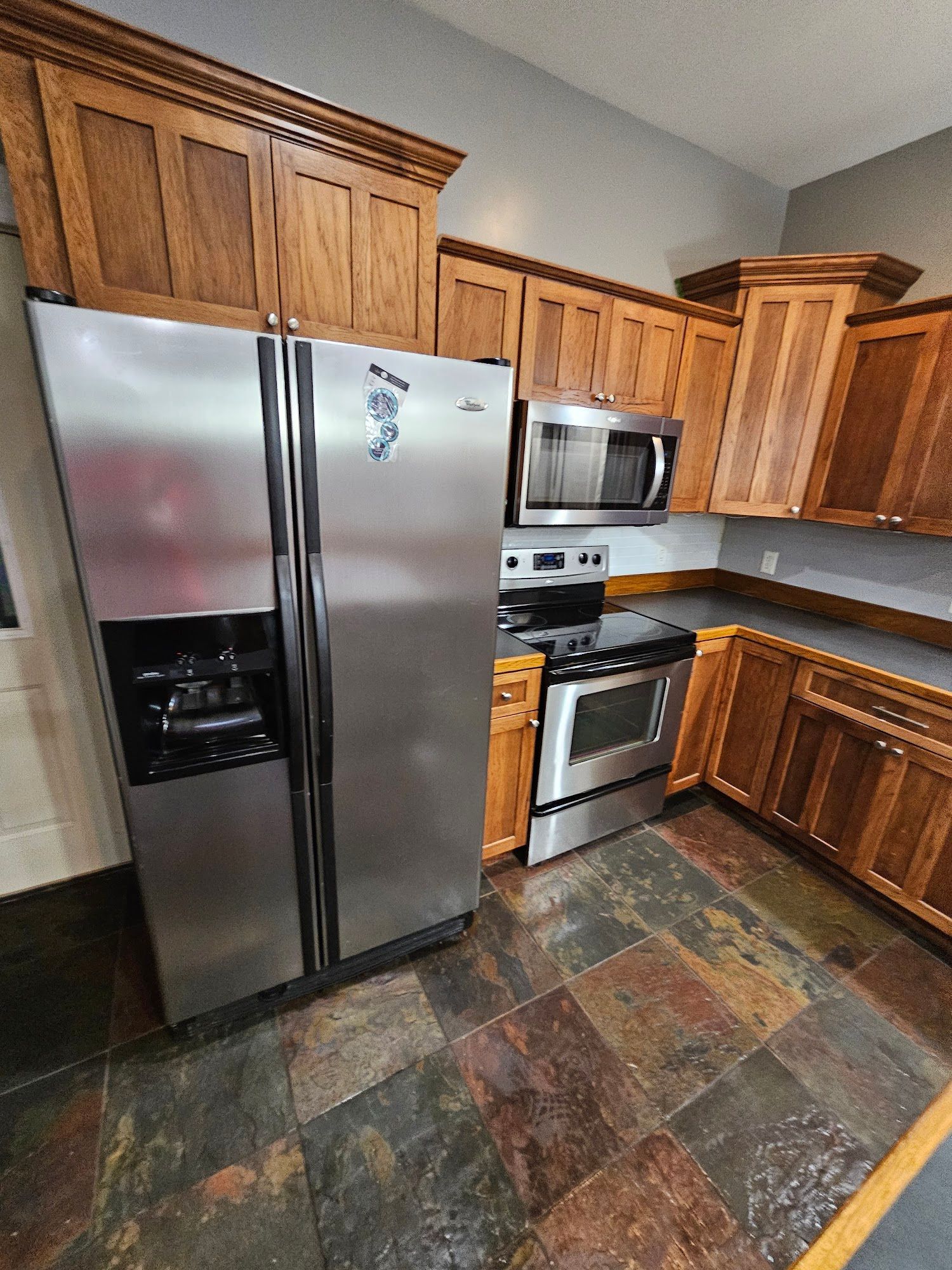 A kitchen with stainless steel appliances and wooden cabinets.
