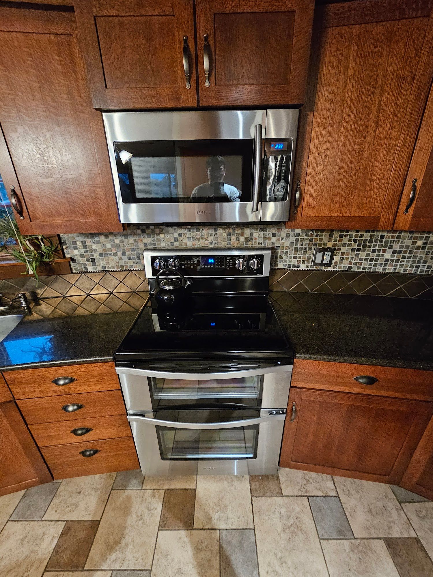 A kitchen with stainless steel appliances and wooden cabinets.