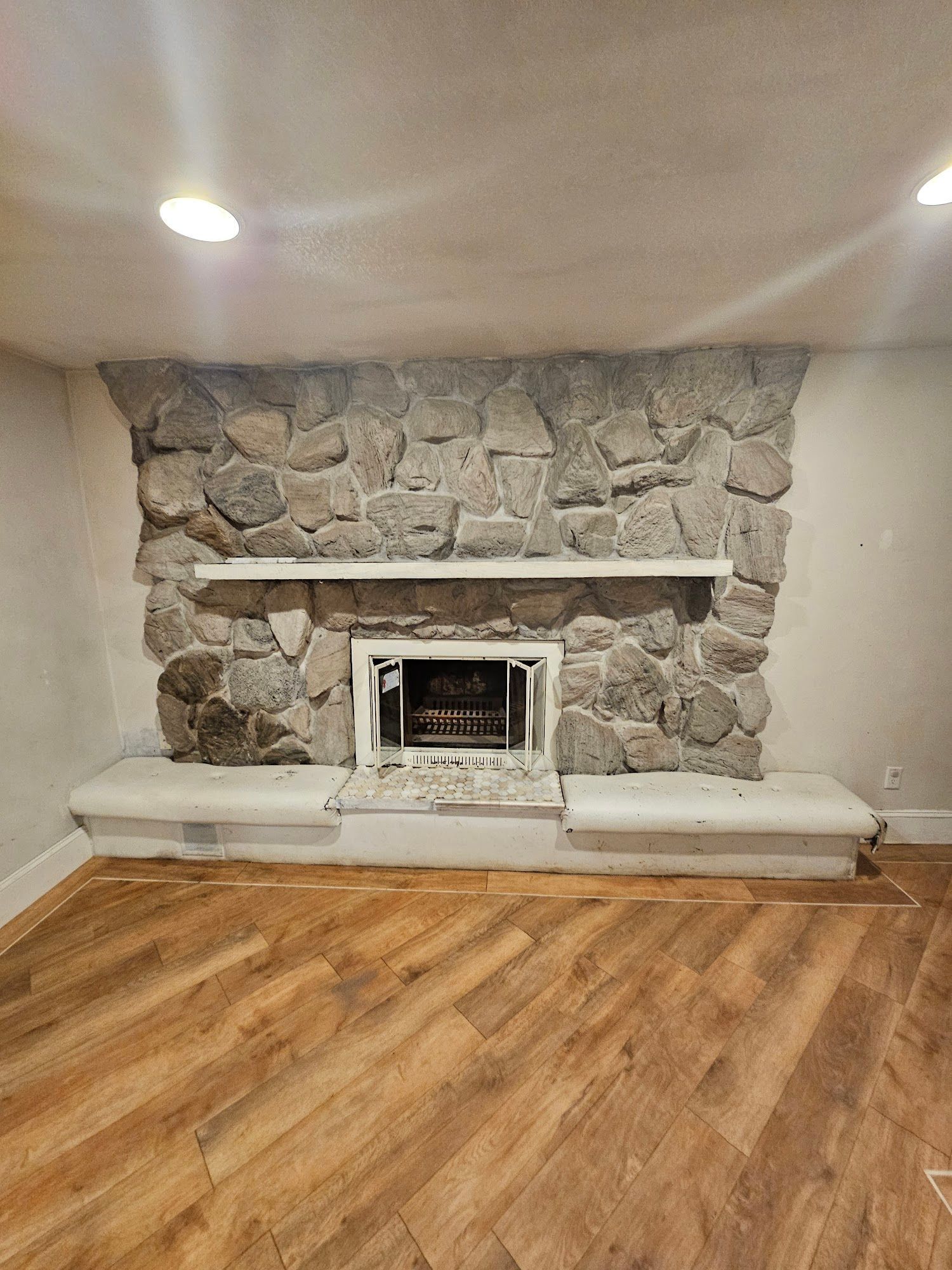 A living room with a fireplace and a wooden floor.