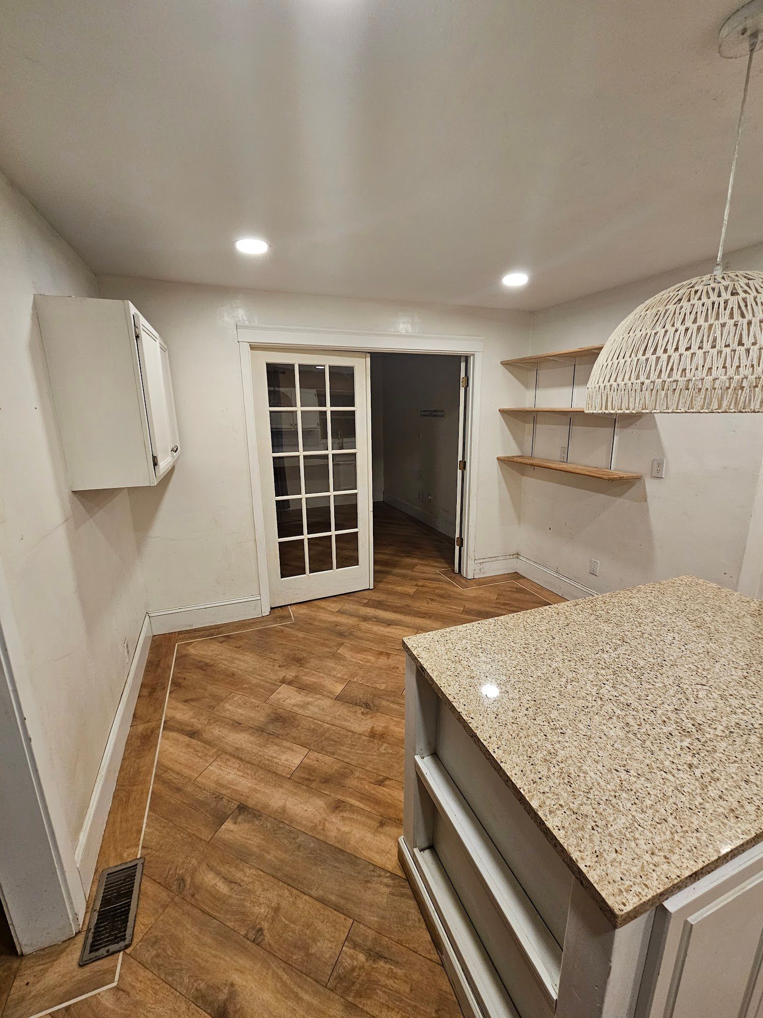 A kitchen with a large island and a sliding glass door.