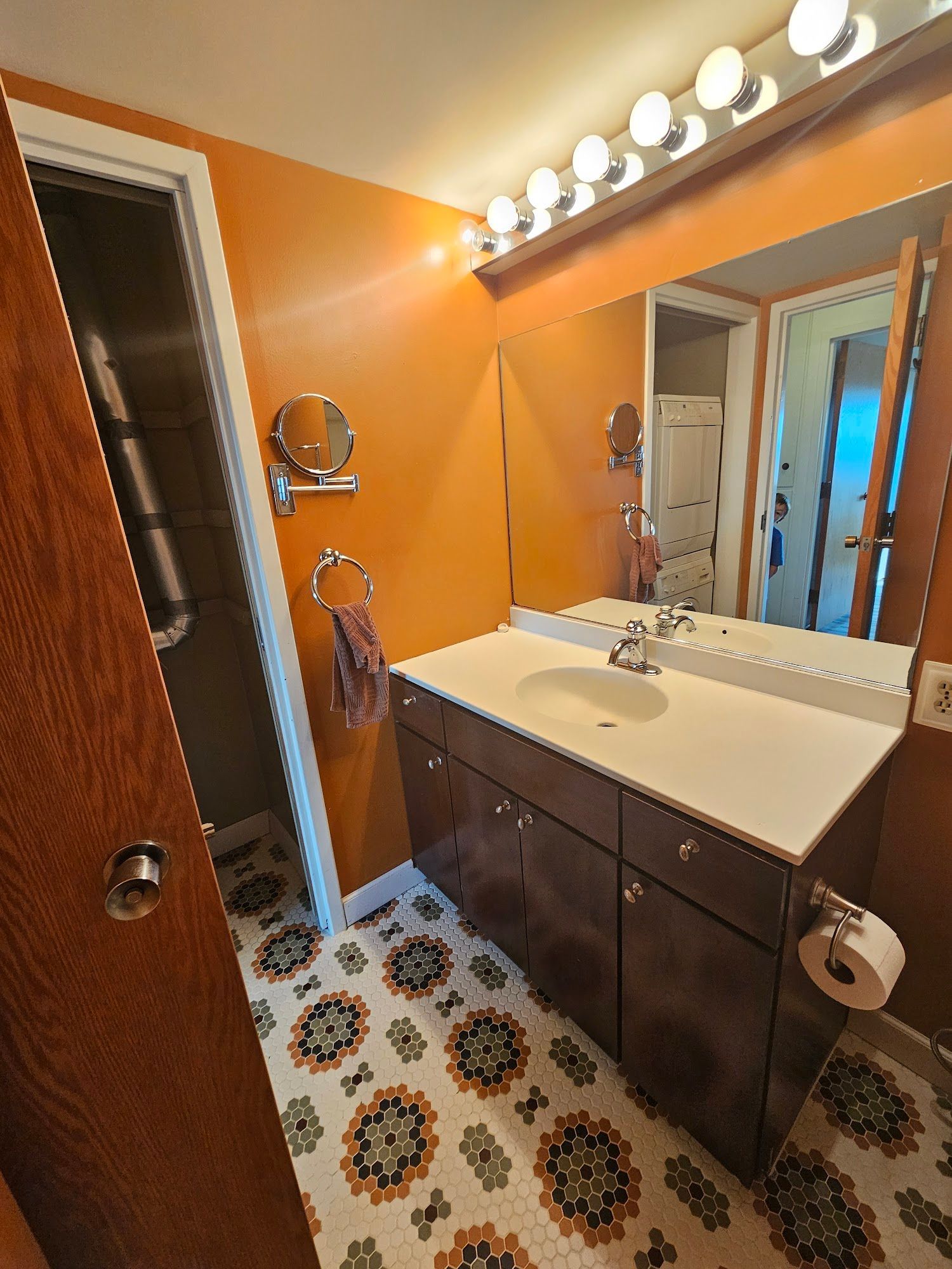 A bathroom with a sink , mirror and toilet.