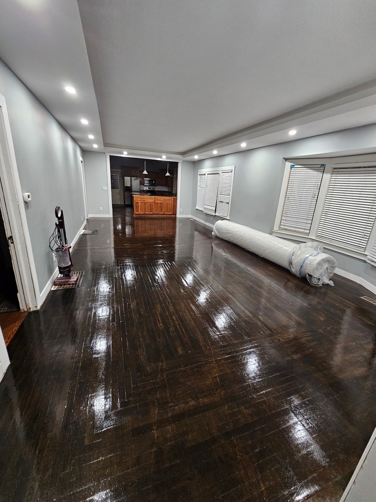 A large empty room with a vacuum cleaner on the floor.