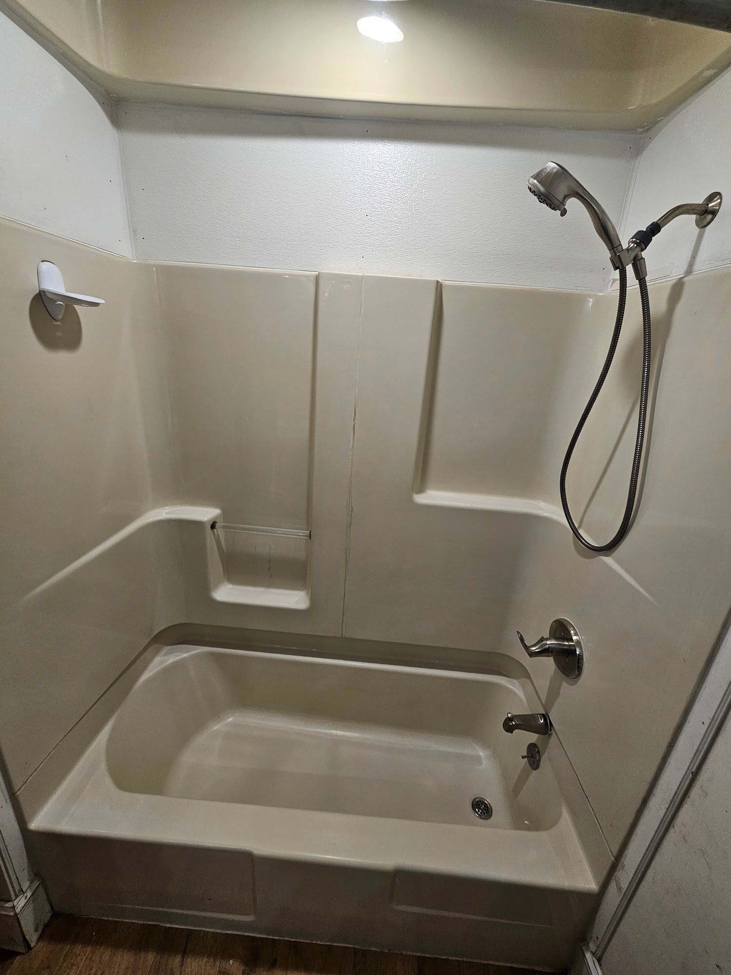 A bathroom with a bathtub and a shower head.