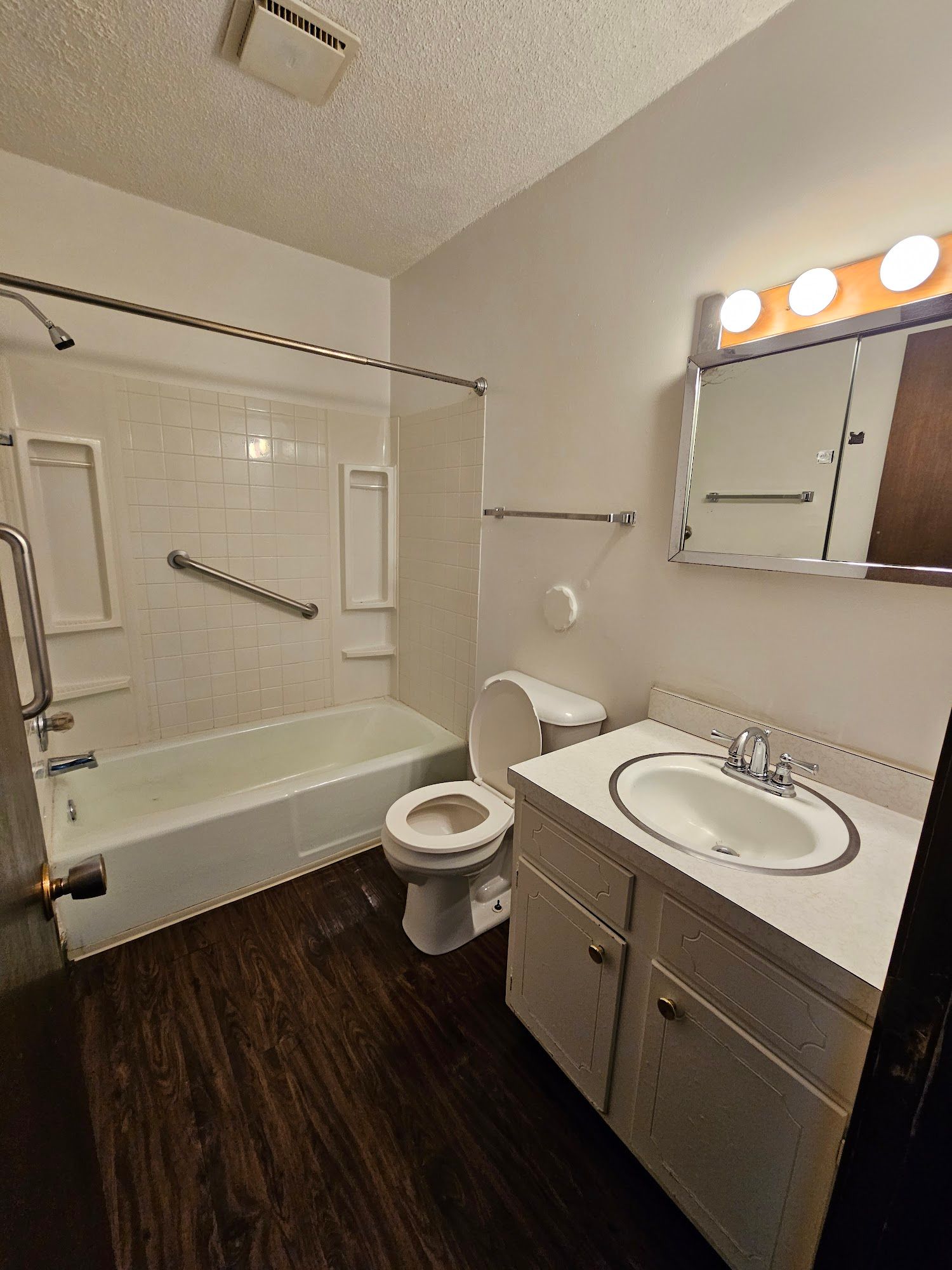 A bathroom with a sink , toilet , bathtub and mirror.