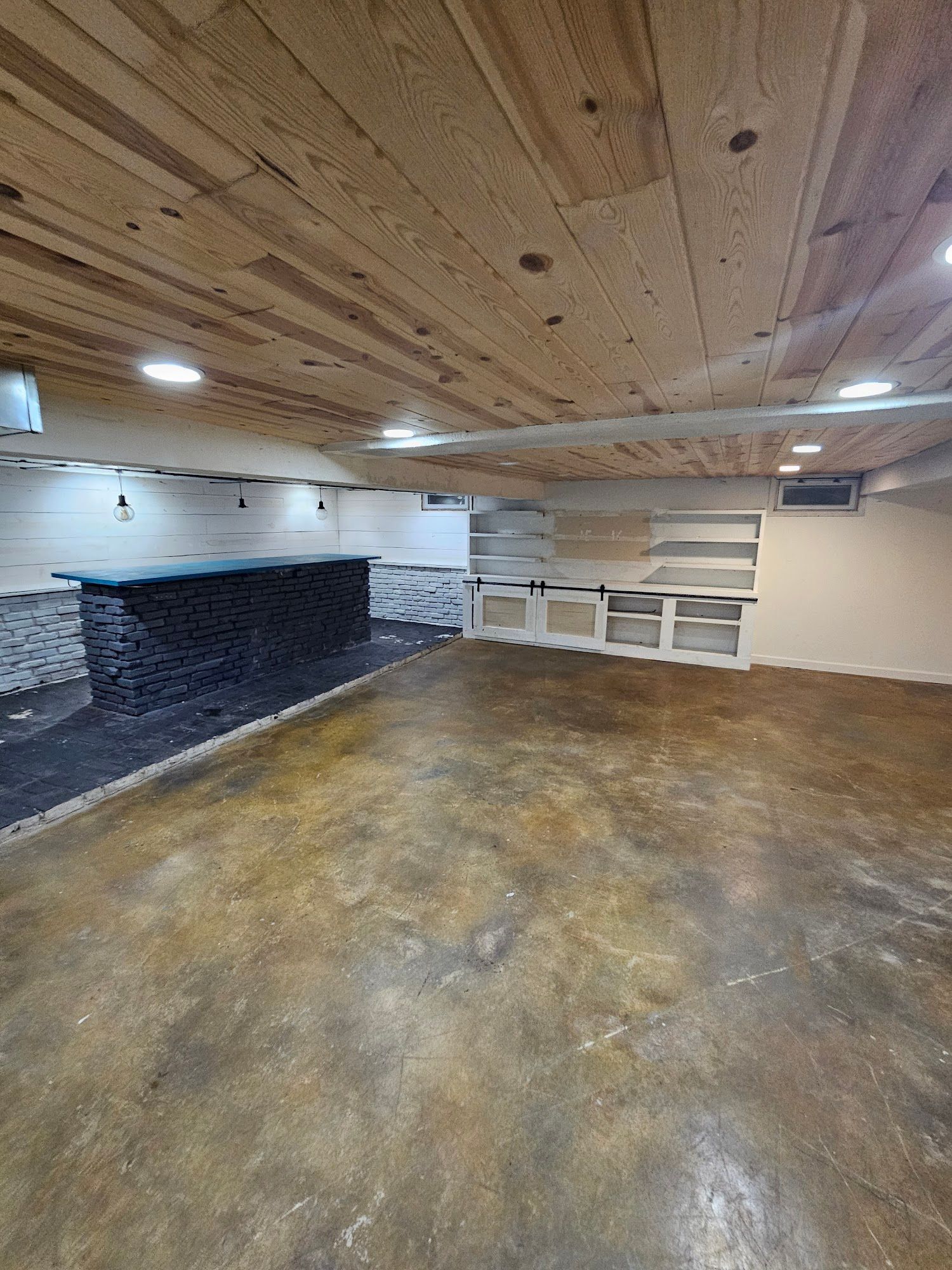 A large empty room with a wooden ceiling and a concrete floor.