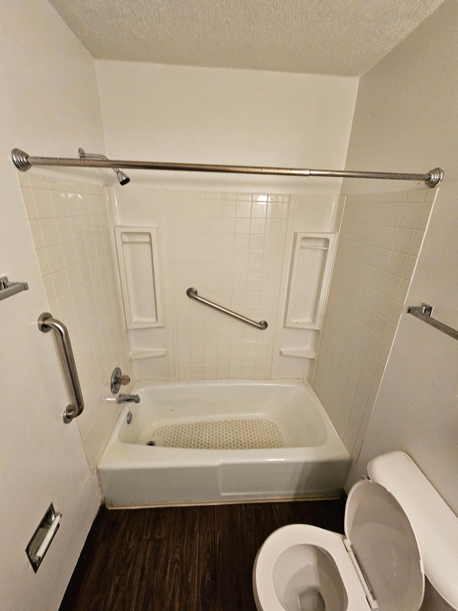 A bathroom with a tub , toilet and shower.