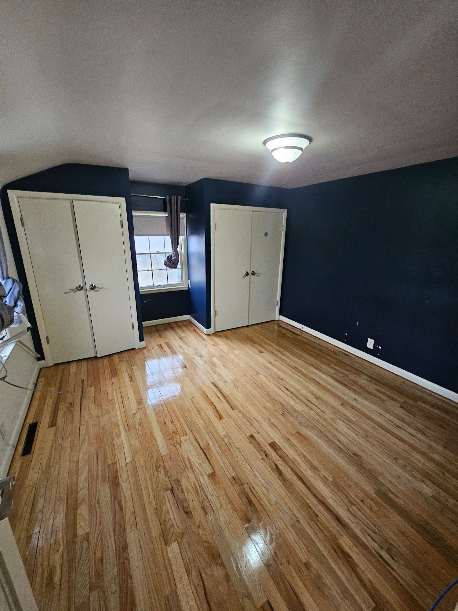 A large empty room with hardwood floors and blue walls.