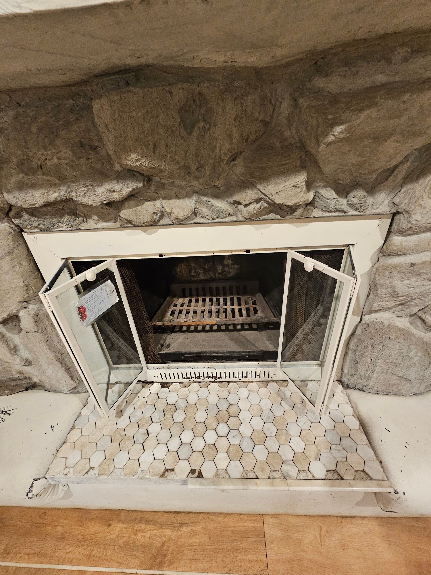A fireplace with a door open that looks like a laptop keyboard.