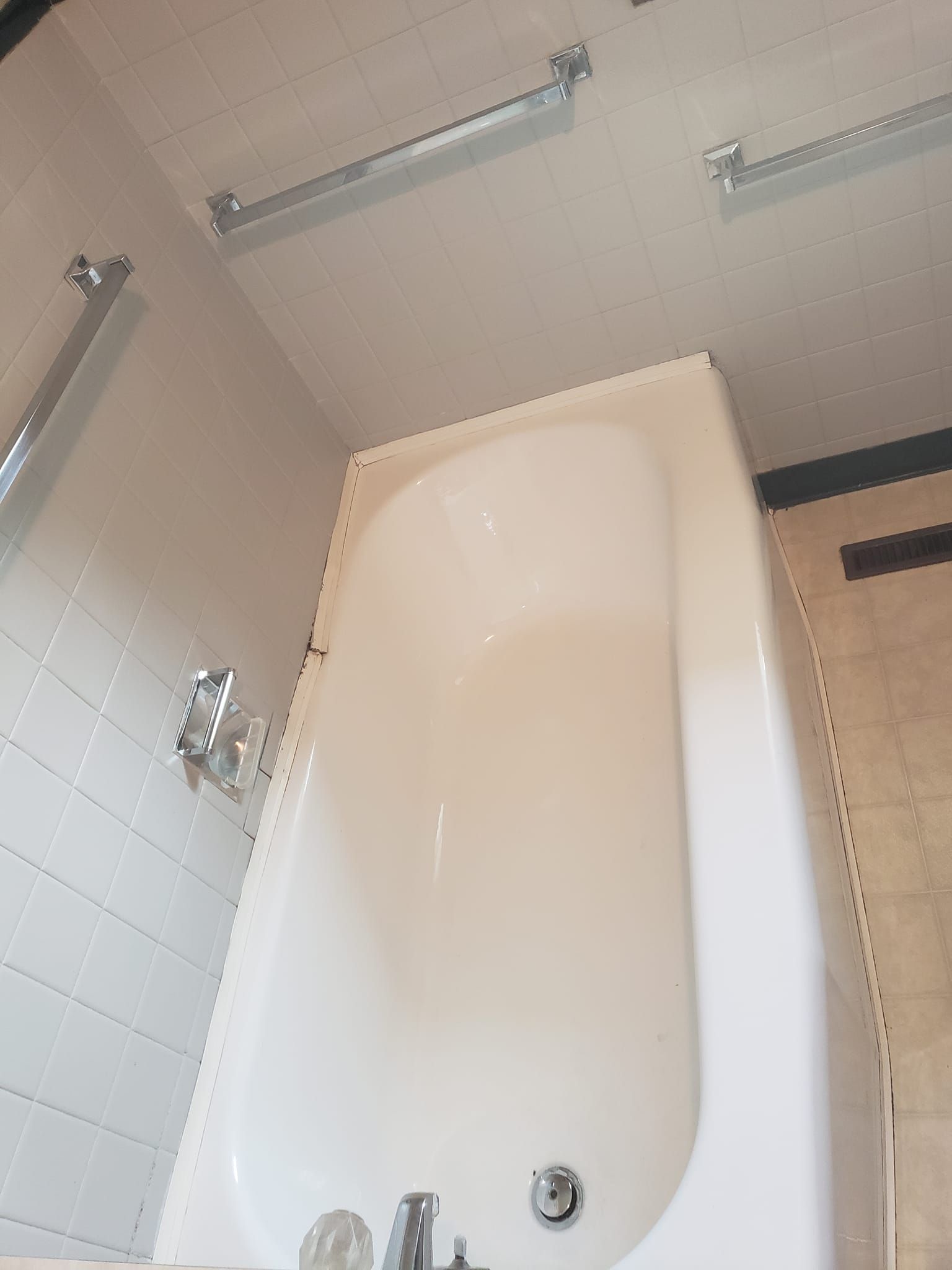 A white bathtub is in a bathroom next to a shower.