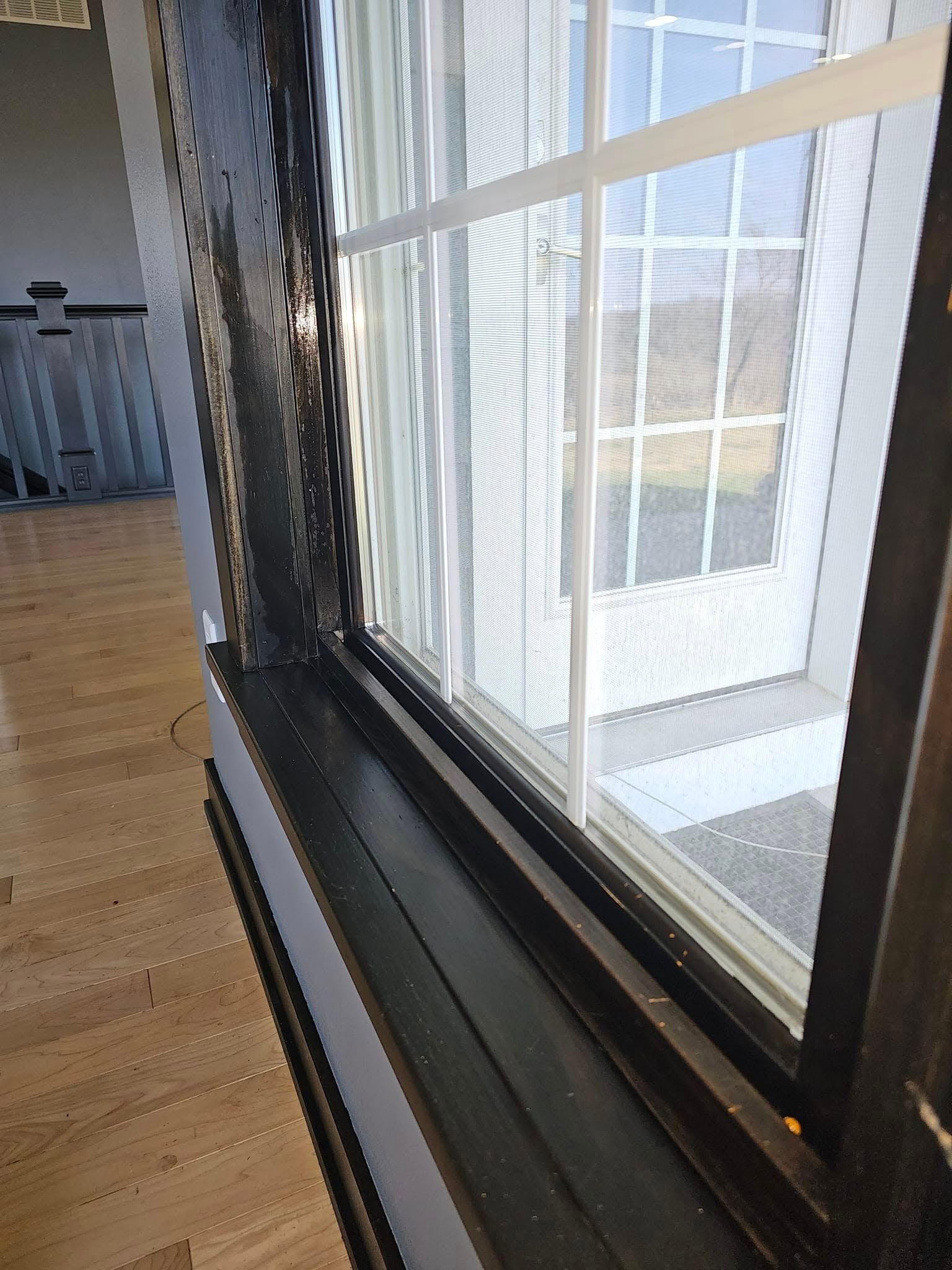 An empty living room with hardwood floors and white walls.