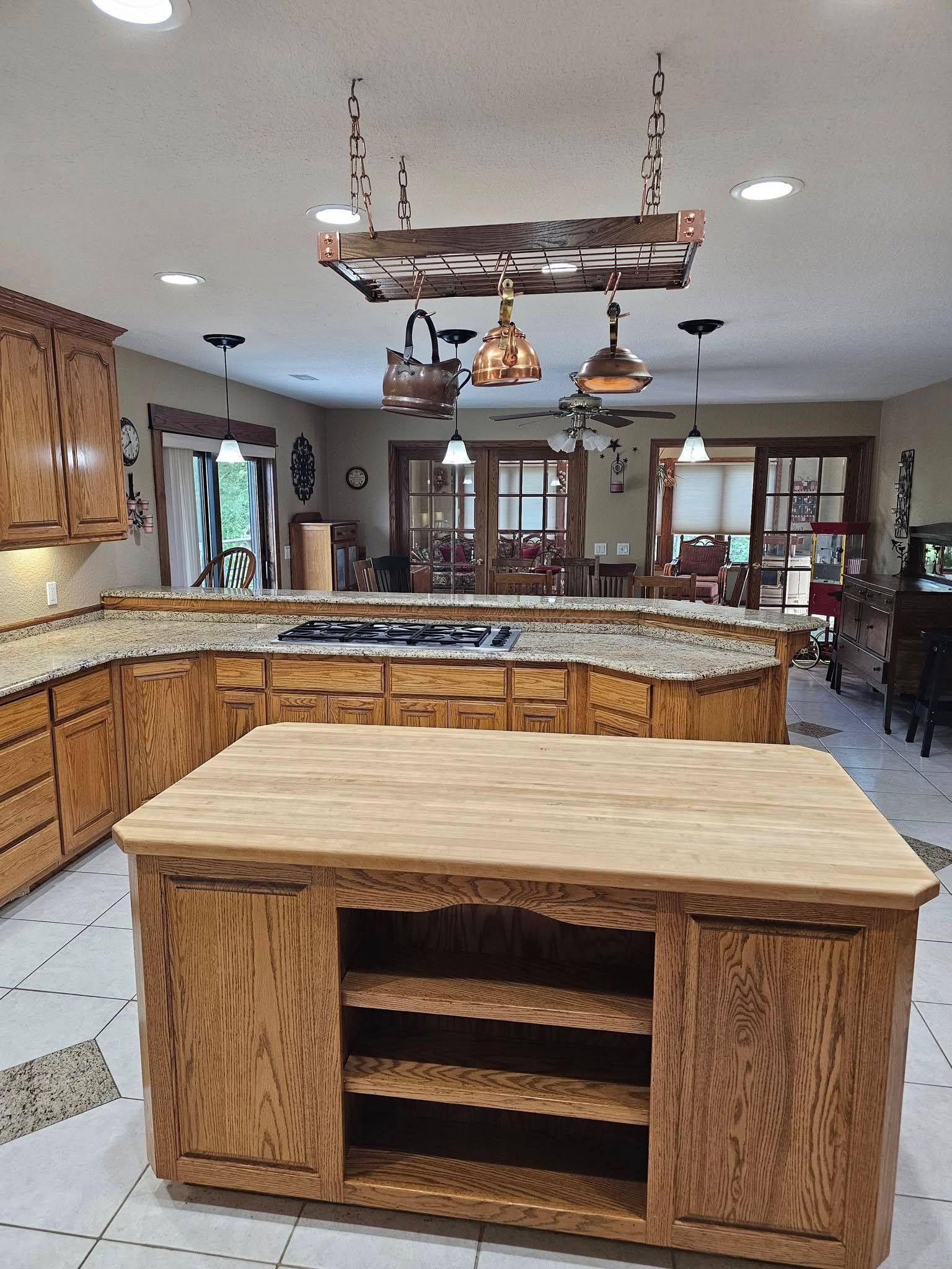 A kitchen with a large wooden island in the middle.