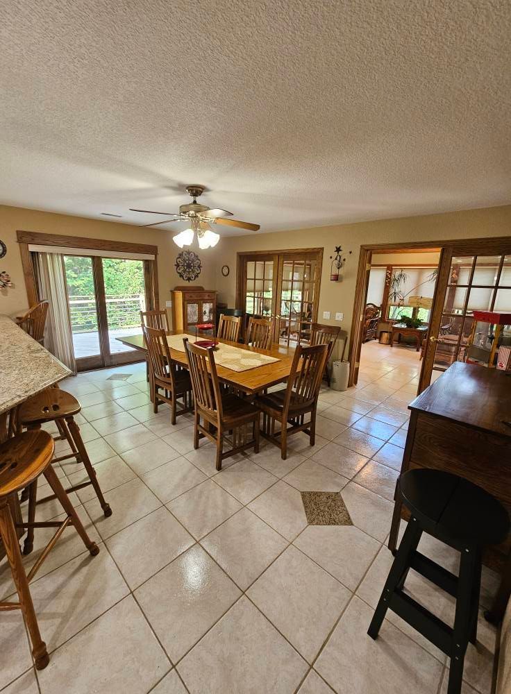 A dining room with a table and chairs and a ceiling fan.
