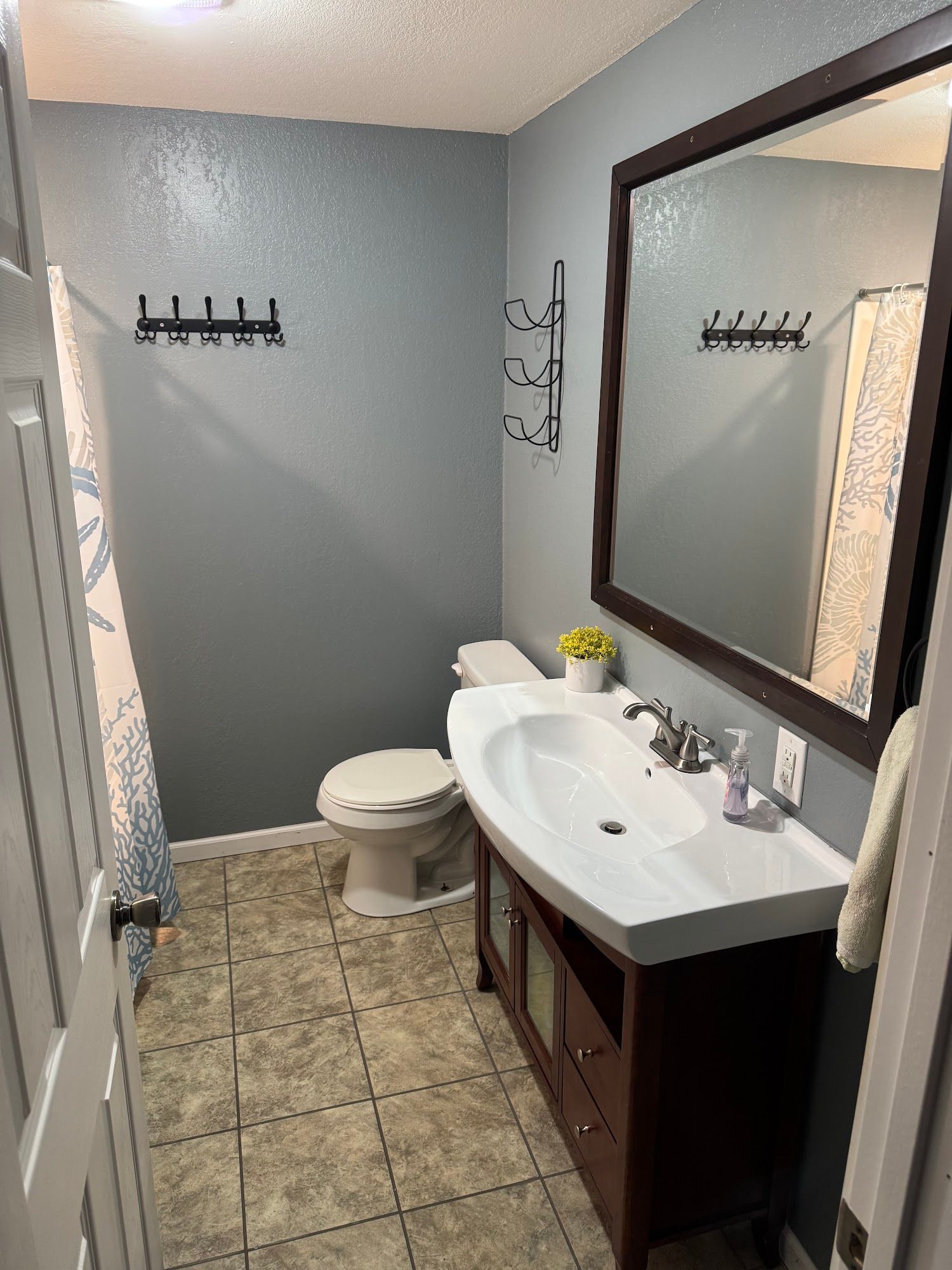 A bathroom with a sink , toilet and mirror.