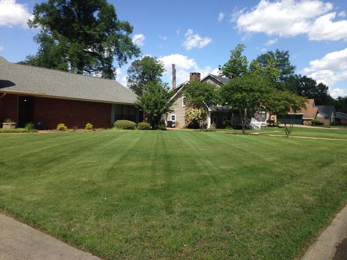 A house with a lush green lawn in front of it