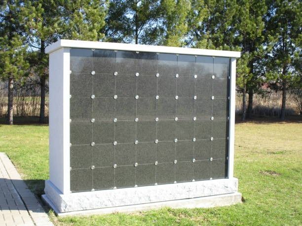 A columbarium with dark panels and white borders in a grassy field.