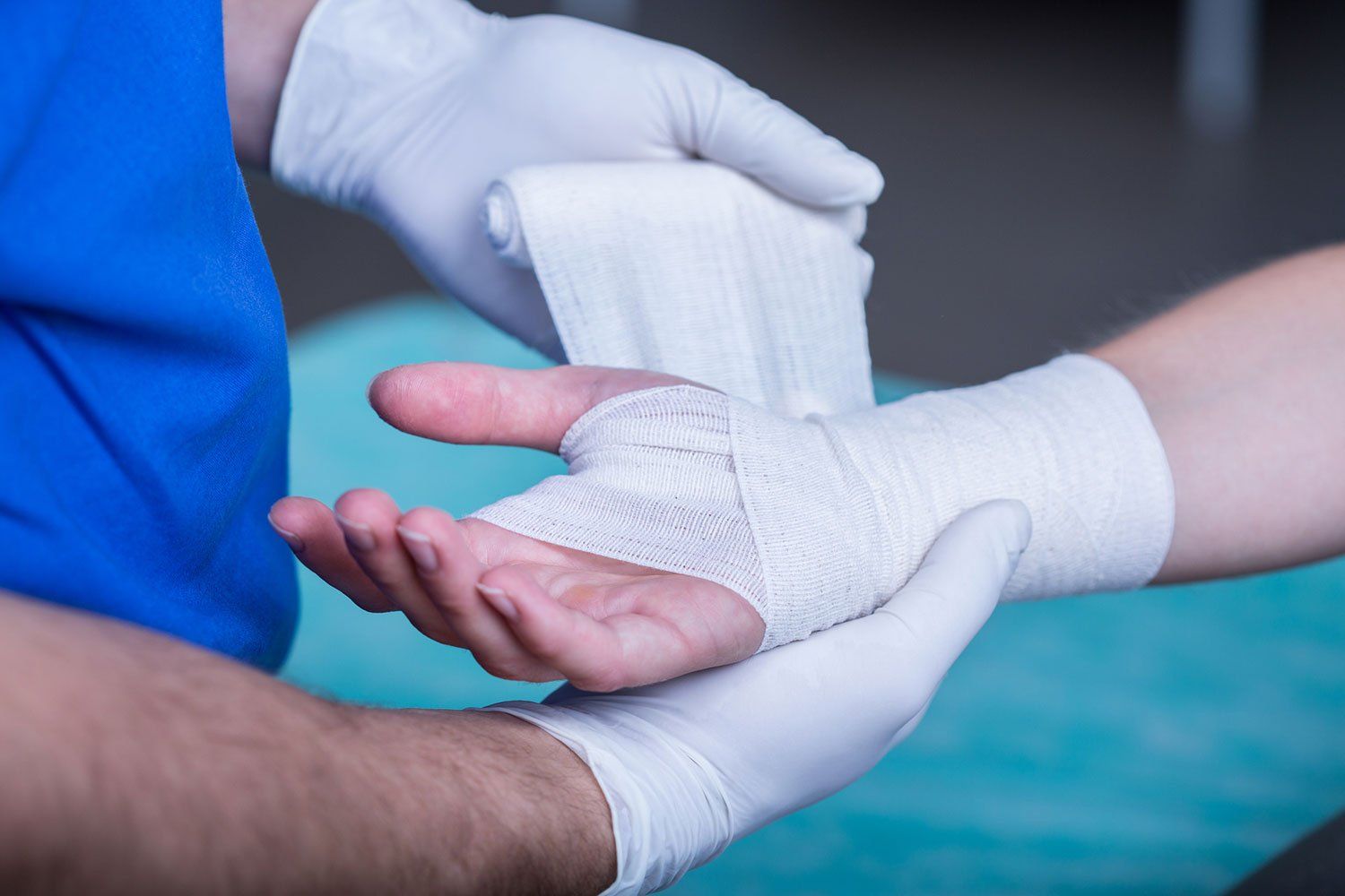 Male Doctor Bandaging a Hand — Winter Haven, FL — Straughn & Turner, P.A.