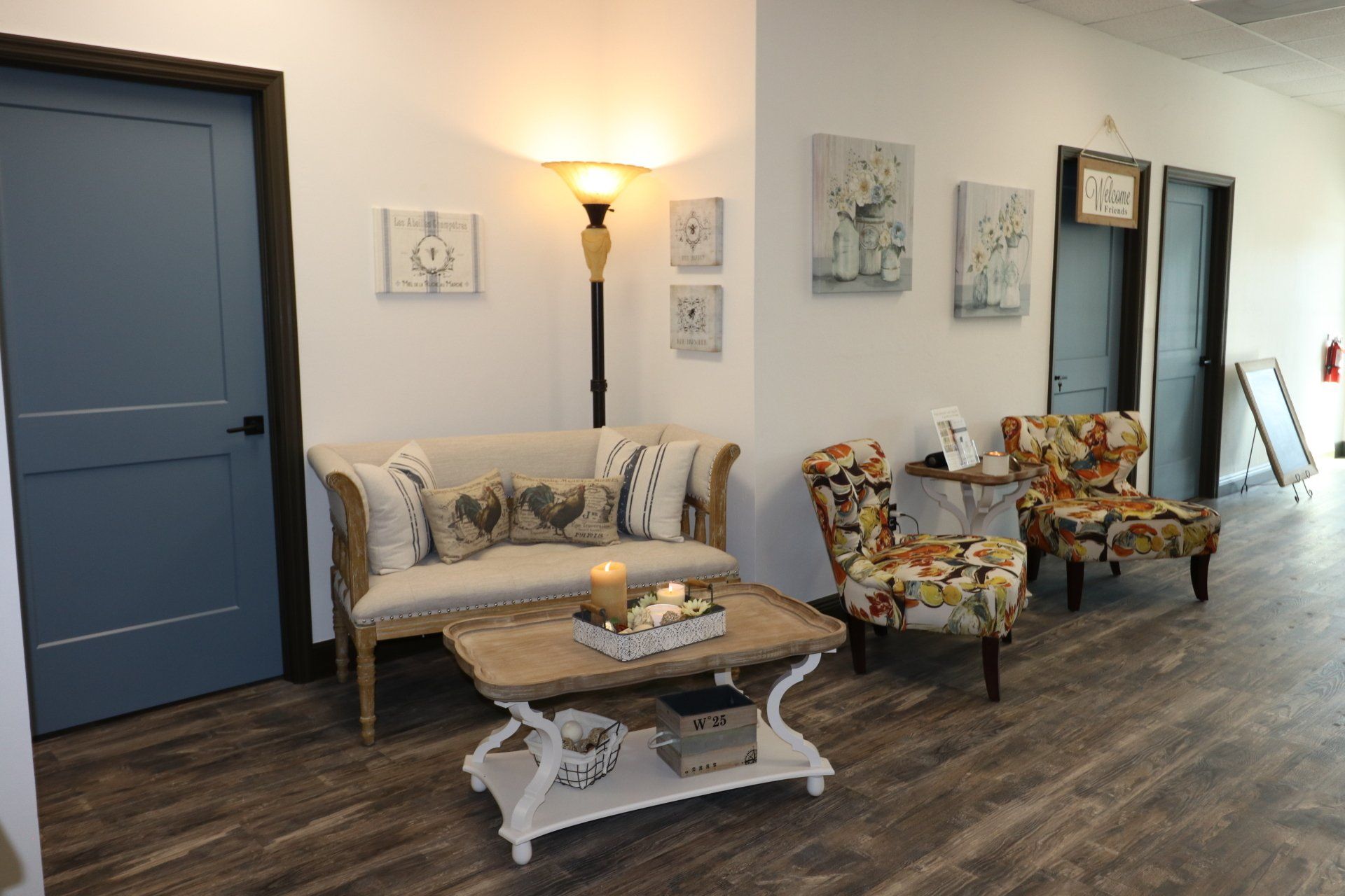 A waiting room with a couch , chairs , and a coffee table at Results Skincare Studio in Fort Myers