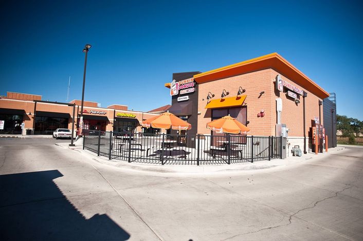 Orange building with outdoor seating; sky blue.