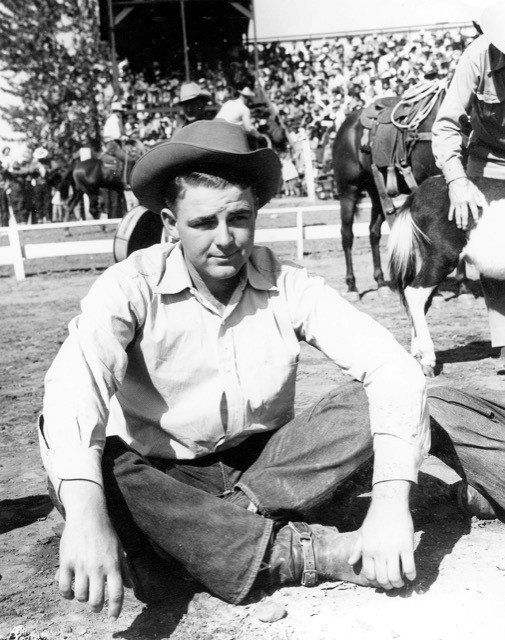 black and white photo of man sitting cross legged on the ground