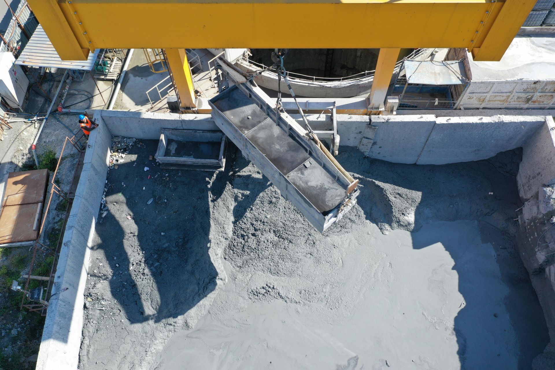 An aerial view of a construction site with a crane pouring concrete